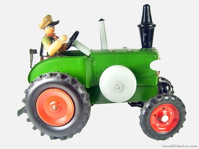 1b grosser gruener Bulldog mit vorderen duennen Metallfelgen und hinteren Holzfelgen